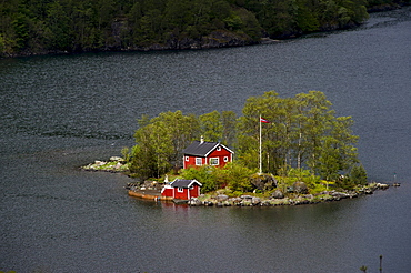 Remote island with a red cottage in Lovrafjord, Norway, Scandinavia, Europe