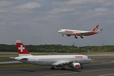 Passenger airplane of Swiss International Air Lines Ltd. on the runway, behind an airberlin airplane departing, Duesseldorf International Airport, Duesseldorf, North Rhine-Westphalia, Germany, Europe