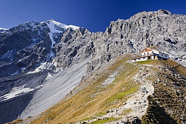 View of the Tabarettahuette mountain lodge, north face of Ortler mountain at the back, during the ascent to the Tabaretta fixed rope route, region of Ortler mountain, province of Bolzano-Bozen, Italy, Europe