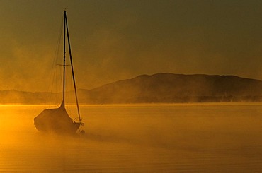 Boat in the early morning on lake Chiemsee, Chiemgau, Upper Bavaria, Germany, Europe