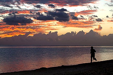 Man jogging at sunset on the beach of Saline-les-Bains, La Reunion island, Indian Ocean