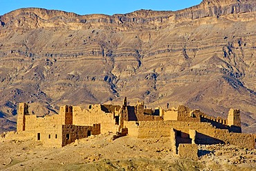 Ruined Kasbah on a hill, a former Berbers' house built of adobe, mountain range of the Djebel Kissane table mountain at the back, Draa Valley, southern Morocco, Morocco, Africa