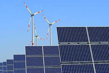 Renewable energy, solar panels in front of wind turbines, composing