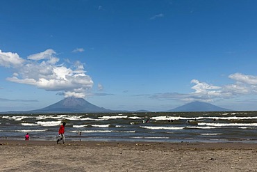 Shallow shore of the Lago de Nicaragua with the volcanic island of Ometepe and the stratovolcanoes Volcan Concepcion, left, and Volcan Maderas, right, at back, San Jorge, Nicaragua, Central America