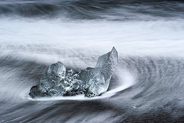 Melting icebergs lying in the strong surf on the black volcanic beach at Joekulsarlon, Iceland, Europe