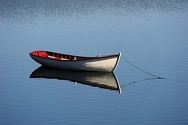 Empty boat on water with reflection, Newfoundland, Canada, North America