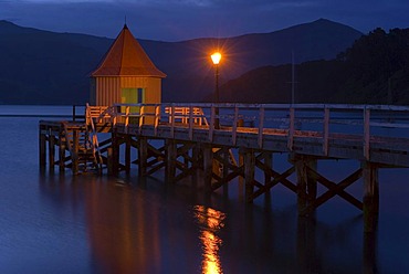 A pier and a lamp in twilight, in Akaroa, Banks Peninsula, Canterbury region, South Island, New Zealand