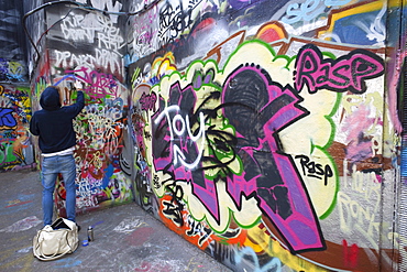 Graffiti artist at work under the Queen Elizabeth Hall, Southbank, London, England, United Kingdom, Europe