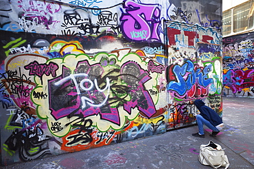 Graffiti artist at work under the Queen Elizabeth Hall, Southbank, London, England, United Kingdom, Europe