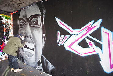 Graffiti artist at work under the Queen Elizabeth Hall, Southbank, London, England, United Kingdom, Europe