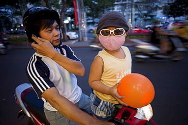 Motorbike passenger wearing pollution mask, Ho Chi Minh City, Vietnam, Indochina, Southeast Asia, Asia 