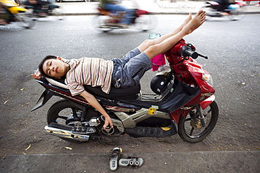 Boy sleeping on motorbike, Ho Chi Minh City, Vietnam, Indochina, Southeast Asia, Asia