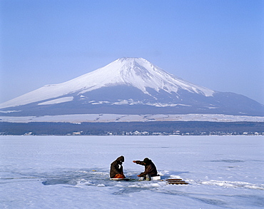 Mount Fuji and fishermen on frozen Lake Yamanaka, Honshu, Japan, Asia