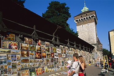 Couple with baby looking at art display, The Florian Gate, Cracow (Krakow), Poland, Europe