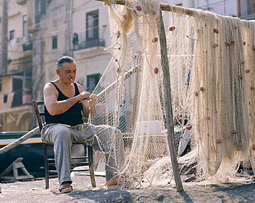 Fisherman making repairs to nets, Genoa (Genova), Liguria, Italy, Europe