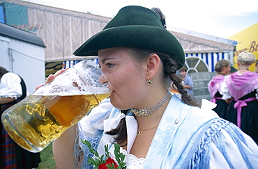 Girl in Bavarian costume drinking beer, Rosenheim, Bavaria, Germany, Europe