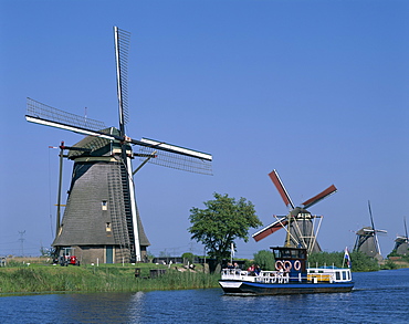 Windmills and tour boat, Kinderdijk, UNESCO World Heritage Site, Holland (Netherlands), Europe