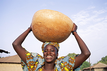 African woman carrying gourd on head, Banjul, Gambia, West Africa, Africa