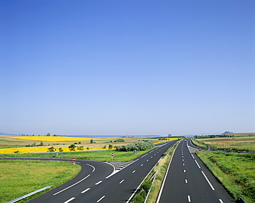 Empty highway with fields of sunflowers in distance, France, Europe
