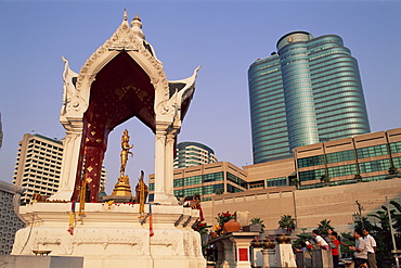 People praying at the Central World Plaza Shopping Centre Shrine with Gaysorn Shopping Mall in the background, Bangkok, Thailand, Southeast Asia, Asia