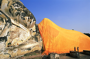 Children praying at giant reclining Buddha statue, Wat Lokaya Sutha, Ayutthaya Historical Park, Ayutthaya, Thailand, Southeast Asia, Asia