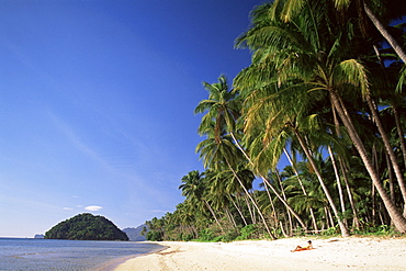 Girl sunbathing on tropical beach, Bascuit Bay, El Nido, Palawan, Philippines, Southeast Asia, Asia