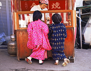 Children dresssed in Yukata at outdoor food stall, Tokyo, Japan, Asia