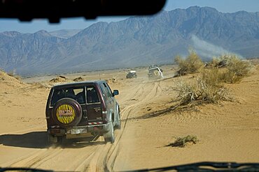 Photograph of a SUV driving through a sand dune in the Jordanian desert