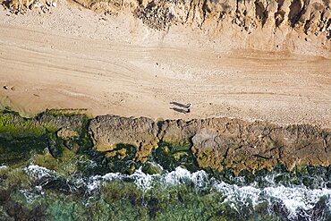 Aerial photograph of a copule strolling on the beach, Israel