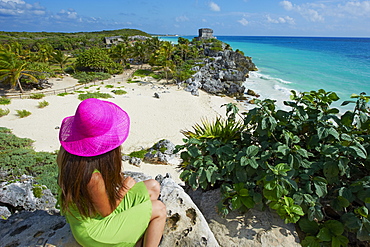 Tourist on the Caribbean coast looking over Tulum Beach to the ancient Mayan site of Tulum, Tulum, Quintana Roo, Mexico, North America