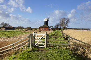 A bright winter day in the Norfolk Broads showing Tall Mill near Upton, Norfolk, England, United Kingdom, Europe