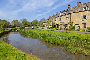 Cottages and footbridge over the River Eye in Lower Slaughter, Cotswolds, Gloucestershire, England, United Kingdom, Europe