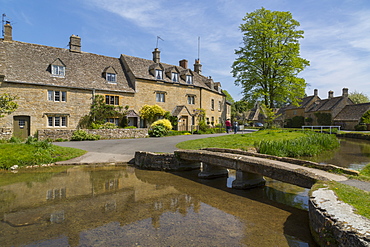 Cottages and footbridge over the River Eye in Lower Slaughter, Cotswolds, Gloucestershire, England, United Kingdom, Europe