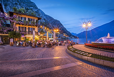 View of illuminated promenade at the port of Limone at dusk, Lake Garda, Lombardy, Italian Lakes, Italy, Europe