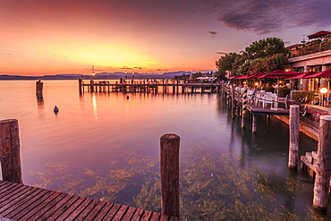 View of golden sunset and restaurant overlooking Lake Garda, Sirmione, Lake Garda, Lombardy, Italian Lakes, Italy, Europe