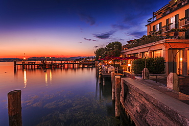 View of golden sunset and restaurant overlooking Lake Garda, Sirmione, Lake Garda, Lombardy, Italian Lakes, Italy, Europe