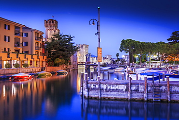 View of Scaliger Castle and boats in harbour at dusk, Sirmione, Lake Garda, Lombardy, Italian Lakes, Italy, Europe