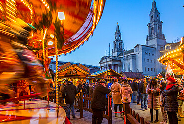 View of carousel and Christmas Market stalls at Christmas Market, Millennium Square, Leeds, Yorkshire, England, United Kingdom, Europe