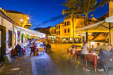 View of cafe in cobbled street in old town at dusk, Funchal, Madeira, Portugal, Europe