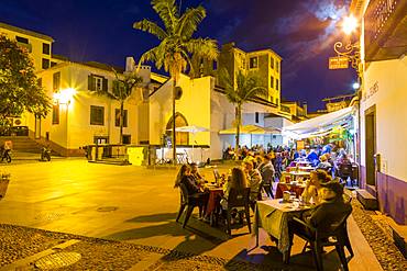 View of cafe in cobbled street in old town at dusk, Funchal, Madeira, Portugal, Europe