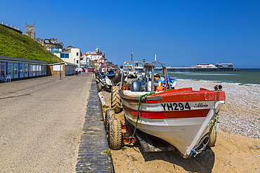 View of Cromer Pier and boats on shingle beach on a summer day, Cromer, Norfolk, England, United Kingdom, Europe