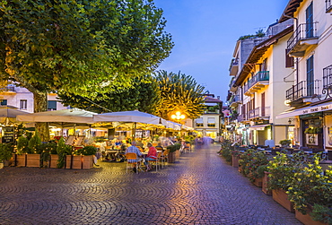 View of restaurants and souvenir shops in Stresa at dusk, Lago Maggiore, Piedmont, Italian Lakes, Italy, Europe