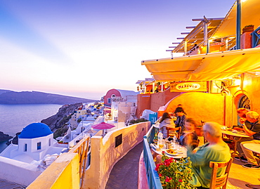 View of restaurant in Oia village overlooking the sea at dusk, Santorini, Cyclades, Aegean Islands, Greek Islands, Greece, Europe