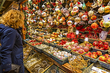 Woman shopping for Christmas decorations at market in Rathausplatz, Vienna, Austria, Europe