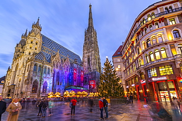 View of St. Stephen's Cathedral, shops and Christmas tree on Stephanplatz at dusk, Vienna, Austria, Europe