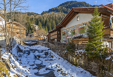 View of frozen river in Canazei town centre in winter, Val di Fassa, Trentino, Italy, Europe