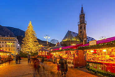 Bolzano Cathedral and long exposure of customers at Christmas Market in Piazza Walther, Bolzano, Italy, Europe