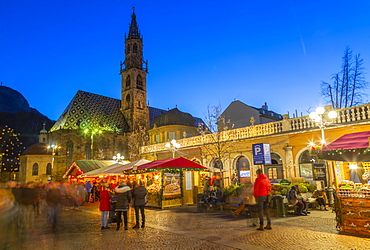 Bolzano Cathedral and long exposure of customers at Christmas Market in Piazza Walther, Bolzano, Italy, Europe