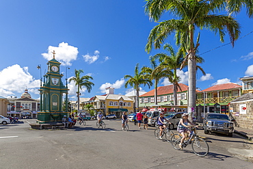 View of cyclists in The Circus and Memorial Clock, Basseterre, St. Kitts and Nevis, West Indies, Caribbean, Central America