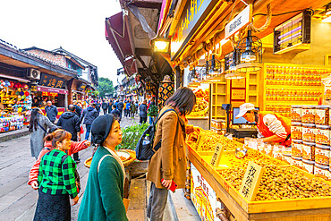 Busy shopping street and local food on display in Ciqikou Old Town, Shapingba, Chongqing, China, Asia